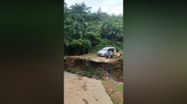Warga berusaha menggotong salah satu pasien yang akan dirujuk ke rumah sakit di kabupaten Barru, melalui jalan amblas di kecamatan Pujananting