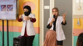 Dokter sedang memberikan edukasi kesehatan tentang perawatan gigi dan mulut bagi ibu hamil dan anak-anak.