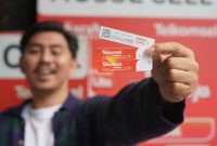 Pelanggan memperlihatkan Voucher Telkomsel