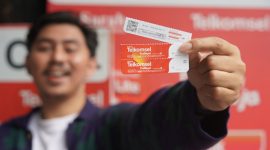 Pelanggan memperlihatkan Voucher Telkomsel