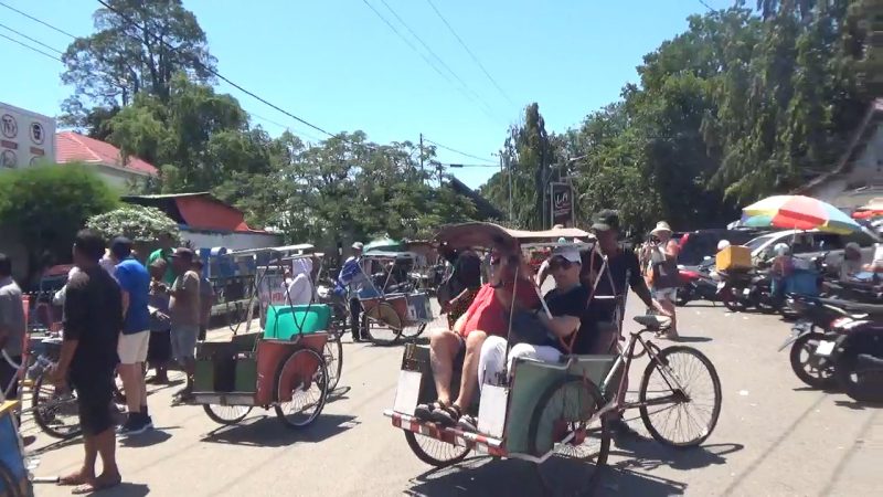 Turis asing sedang menggunakan alat transportasi tradisional becak berkeliling kota Parepare