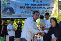 Danyon B Pelopor Kompol Ramli saat menyerahkan daging kurban kepada warga kaum dhuafa di hari raya Idul Adha 1446 Hijriyah