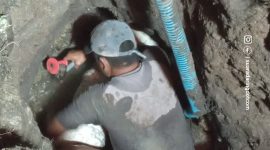 Salah satu petugas PAM Tirta Karajae sedang memperbaiki pipa bocor
