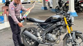 Salah satu anggota Sat Lantas Polres Parepare memperlihatkan sepeda motor yang diamankan petugas karena menggunakan knalpot brong