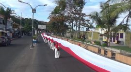 Sejumlah ibu-ibu mengangkat bendera sepanjang 180 meter yang diarak sejauh 7 kilometer