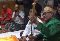 anggota komisi X DPR RI dari fraksi PKB, H.Andi Muwiyah Ramly, membuka salah satu benda pusaka berupa keris dari sarungnya yang akan dicuci dalam kegiatan Mattompang