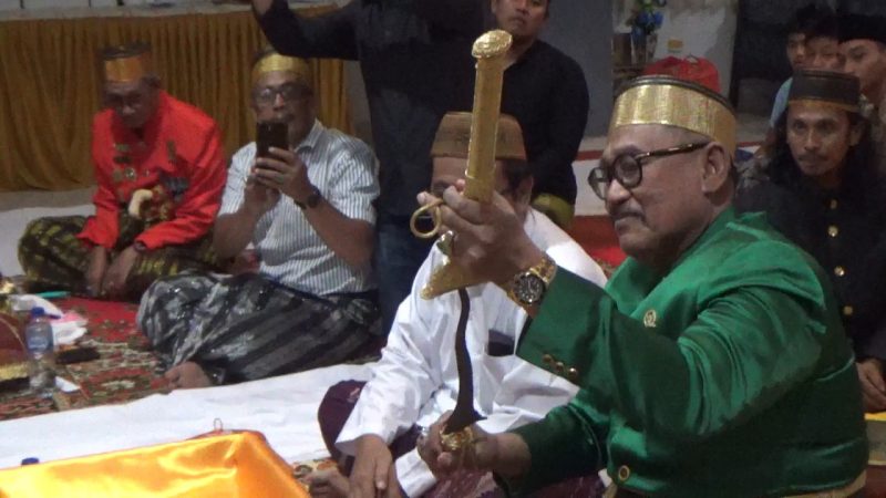 anggota komisi X DPR RI dari fraksi PKB, H.Andi Muwiyah Ramly, membuka salah satu benda pusaka berupa keris dari sarungnya yang akan dicuci dalam kegiatan Mattompang