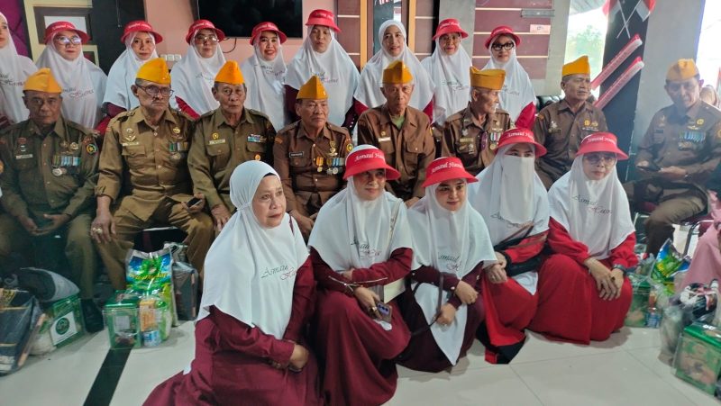 Kelompok pengajian Asmaul Husna berfoto bersama dengan penerima usai penyerahan paket