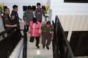 Tersangka inisial HM megenakan rompi berwarna pink terlihat menuruni anak tangga dengan pengawalan ketat dari pihak Kejari Parepare, usai menjalani pemeriksaan 