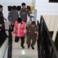 Tersangka inisial HM megenakan rompi berwarna pink terlihat menuruni anak tangga dengan pengawalan ketat dari pihak Kejari Parepare, usai menjalani pemeriksaan 