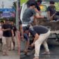 Sappe bersama dengan anak muda sekitar sedang menambal jalan jembatan Sumpang Minangae yang berlubang