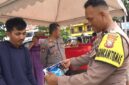 Seorang Bhabinkamtibmas Polsek Bacukiki Polres Parepare, sedang memeriksa beras premium yang dikeluarkan Bulog cabang Parepare berukuran 5Kg saat Gerakan pangan murah (GPM)
