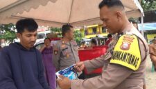 Seorang Bhabinkamtibmas Polsek Bacukiki Polres Parepare, sedang memeriksa beras premium yang dikeluarkan Bulog cabang Parepare berukuran 5Kg saat Gerakan pangan murah (GPM)