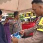 Seorang Bhabinkamtibmas Polsek Bacukiki Polres Parepare, sedang memeriksa beras premium yang dikeluarkan Bulog cabang Parepare berukuran 5Kg saat Gerakan pangan murah (GPM)
