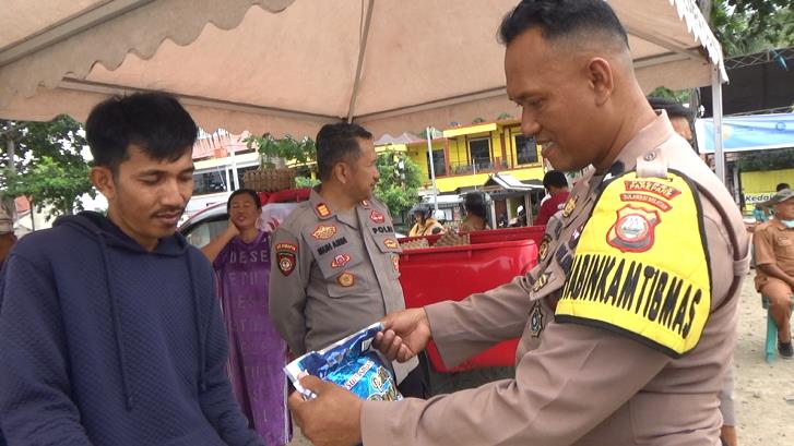 Seorang Bhabinkamtibmas Polsek Bacukiki Polres Parepare, sedang memeriksa beras premium yang dikeluarkan Bulog cabang Parepare berukuran 5Kg saat Gerakan pangan murah (GPM)