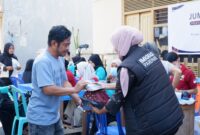 Petugas Imigrasi kelas II TPI Parepare menyerahkan bingkisan kepada salah satu peserta Jumat Peduli