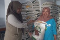 Pimpinan Cabang Bulog Parepare, Rahmi Mangerang menyerahkan beras bantuan kepada PBP saat memantau penyaluran Banpang di kantor kelurahan Lemoe kota Parepare.
