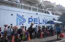 Penumpang mangantre di dermaga naik ke atas kapal milik PELNI