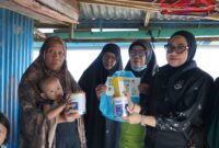 Petugas Imigrasi kelas II TPI Parepar menyerahkan susu sebagai tambahan nutrisi kepada penerima manfaat dalam Bakti Sosial melalui Program Orang Tua Asuh Anak Stunting 
