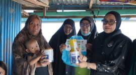 Petugas Imigrasi kelas II TPI Parepar menyerahkan susu sebagai tambahan nutrisi kepada penerima manfaat dalam Bakti Sosial melalui Program Orang Tua Asuh Anak Stunting 
