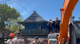Tim SAR Sat Brimob Batalyon B Pelopor Polda Sulsel, memadamkan api yang menyambar salah satu rumah warga akibat kebakaran lahan