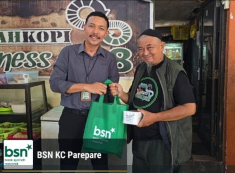 (Kiri) Pimpinan cabang BSN Parepare, Kumala Jodie  Pranata L memberikan souvenir kepada nasabah baru 