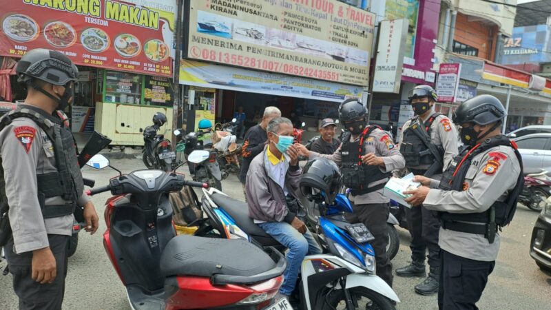 Personel Brimob Parepare bagikan masker kepada warga akibat asap tebal selimuti kota Parepare, Sulawesi selatan 