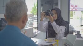 Seorang petugas Imigrasi sedag mengambil foto pemohon untuk kepentingan dokumen penerbitan paspor