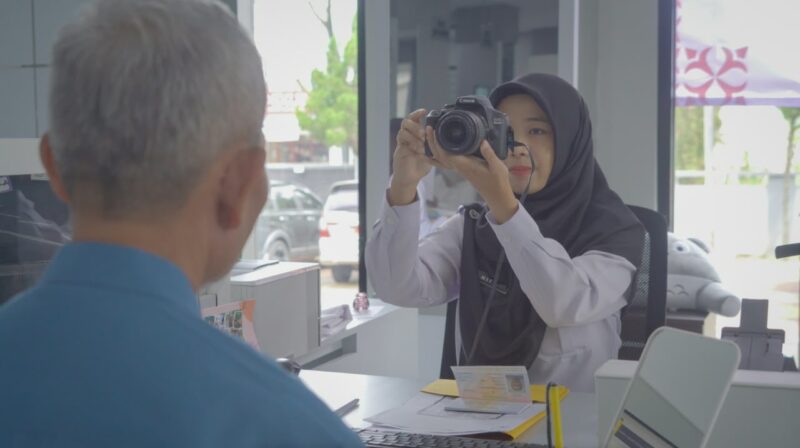 Seorang petugas Imigrasi sedag mengambil foto pemohon untuk kepentingan dokumen penerbitan paspor